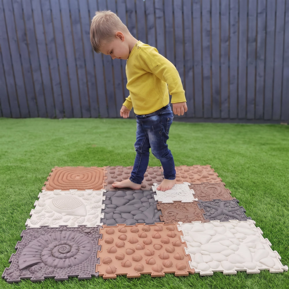 Kindervoeten op gras naast kindervoeten op de Orthoplay mat